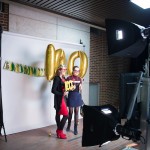 Seen here, a photobooth was set up to allow guests to capture the night. Custom props were created for the booth - a garland in U of A colors, a giant '100' balloon, glitter '100's to hold up , and more!