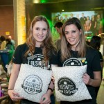 Event volunteers holding up Centennial branded pillows that were used in soft seating areas.