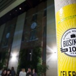 Centennial pillar wraps and the Centennial logo projected on the brick wall.